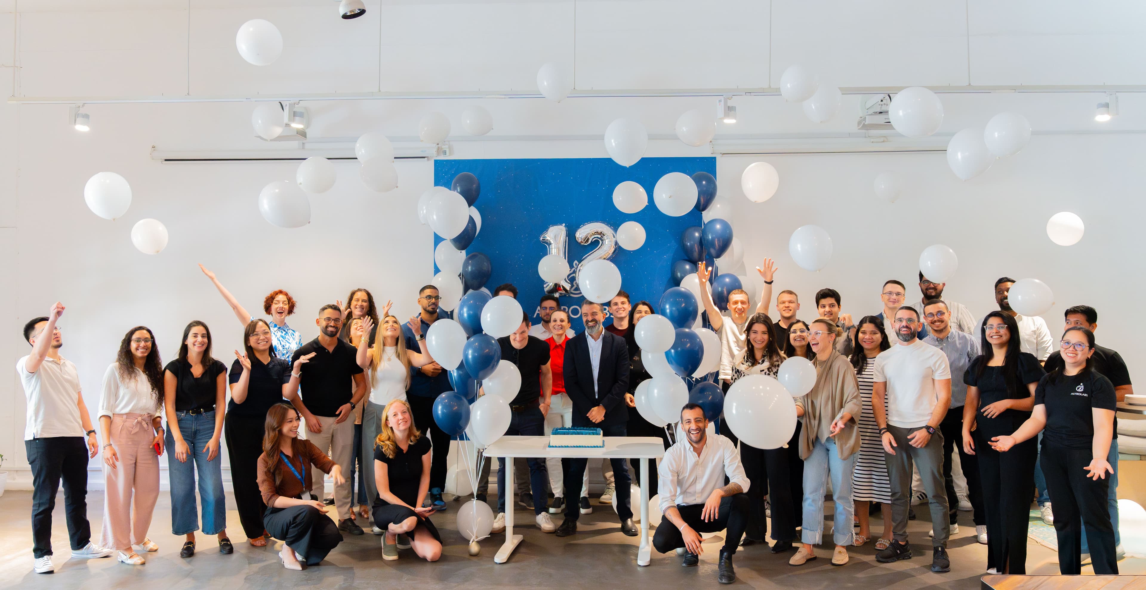four people walking while holding coffee in office